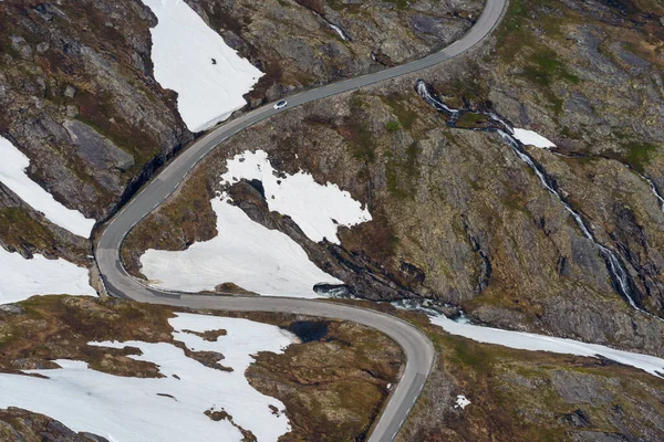 GEIRANGER, NORway - 2020 HAZİRAN 21 HAZİRAN Dağın tepesinde, yanında karla birlikte virajlı yol.
