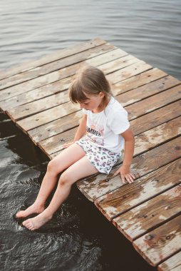 Anne ve kızı plajda gün batımında oynuyorlar.
