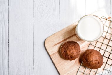 Muzlu kekler ve bir bardak süt beyaz ahşap masada fotokopi alanı ile.