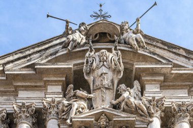 Katedralin bir parçasının altında mavi bir gökyüzünün arka planına karşı pedikürde antik heykeller var.