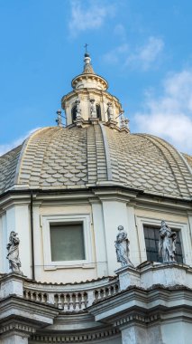 Katedralin bir parçasının altında mavi bir gökyüzünün arka planına karşı pedikürde antik heykeller var.