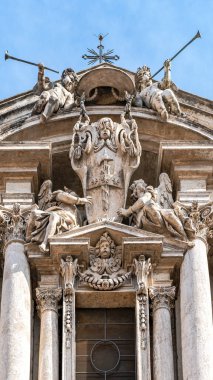 Katedralin bir parçasının altında mavi bir gökyüzünün arka planına karşı pedikürde antik heykeller var.