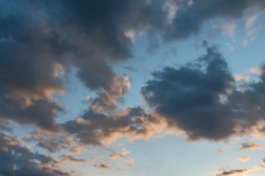Akşam güneşi doğal bir zemin olarak belirleyen koyu bulutlu mavi gökyüzü.