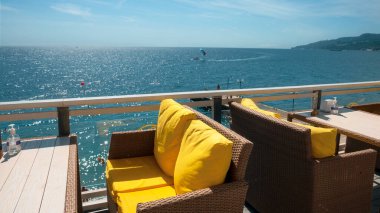 Karadeniz kıyısındaki bir kafede hasır söğüt sandalyeleri ve ahşap masalar.