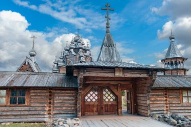 Rusya 'nın St. Petersburg şehrinin banliyölerindeki tarihi ahşap bir kiliseye açılan ahşap bir kapı mavi bulutlu bir gökyüzünün arka planına karşı.