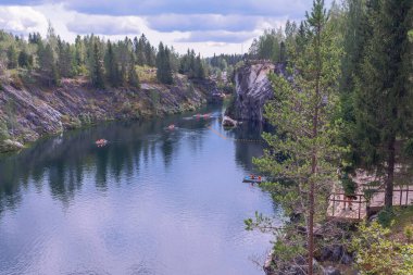 su dolu antik mermer ocağı ve turistlerin olduğu sayısız tekne.