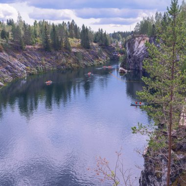 su dolu antik mermer ocağı ve turistlerin olduğu sayısız tekne.