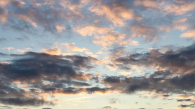 Büyük koyu kümülüs bulutlarıyla mavi gökyüzü akşam güneşi doğal bir arka plan olarak aydınlatıyor.