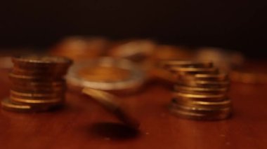Para dolu bir masada dönen bir avroluk paranın yavaş çekim videosu.