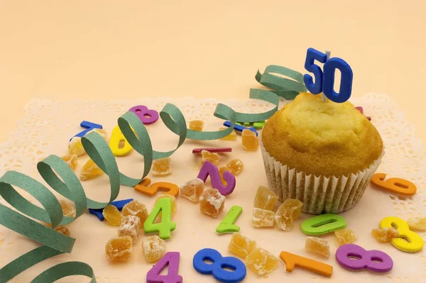 Birthday concept, a cupcake with the number 50, jelly beans and numbers background