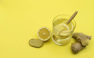 Sarı arka planda limon ve taze zencefil karışımı kış nezlesi.
