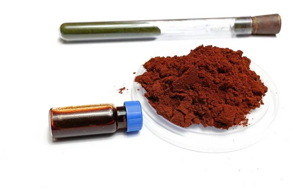 Beyaz arka planda toz halinde Sangre de drago adı verilen parmak izi geliştirmek için kullanılan bir reaktör gösterilir ve sıvı halde bir şişede çözünür, tıpta iyileştirici özellikleri vardır.