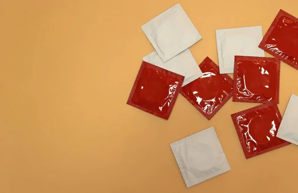 Varios Condones Rojos Blancos Sin Abrir Sobre Fondo Naranja Concepto — Foto de Stock