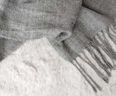 Beyaz arkaplanda gri rengin yün atkısı, üst görünüm, metin için boşluk. Kış giysileri