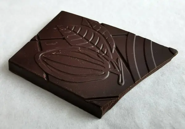 Nahaufnahme Auf Einem Quadratischen Stück Dunkler Schokolade Auf Weißem Hintergrund — Stockfoto