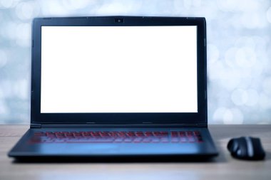 Ofis masasında boş beyaz ekran ve kablosuz fare olan dizüstü bilgisayar