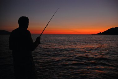 gün batımında deniz balıkçı