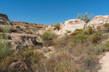 Güney İspanya 'daki eski bir madenden gelen çökeltiler, bitki örtüsü var ve gökyüzü açık.