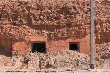 Güney İspanya 'daki eski mağara evinde bir kapı ve pencere var. Metal bir sütun var. Taş ve ahşap var.