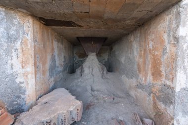 Bir maden tesisinden çıkış kapısı, çıkış metalden ve toprak var, tuğla var.