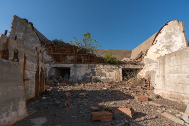 Güney İspanya 'da terk edilmiş bir maden tesisinde inşaat taş, tuğla ve betondan yapılmıştır. Ağaçlar ve çalılar vardır. Gökyüzü açıktır.