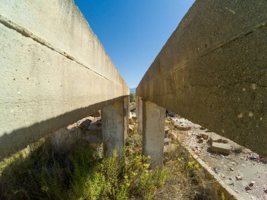 Güney İspanya 'da terk edilmiş bir maden tesisinde inşaat, taş, tuğla ve betondan yapılmış, çalılar var, gökyüzü açık.