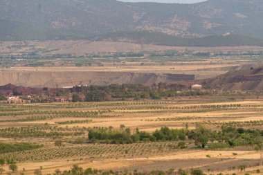 Güney İspanya 'da tarım arazileri, çimenler kuru, ağaçlar ve dağlar var, gökyüzünde çok az bulut var.