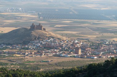 La Calahorra Kalesi bir dağın tepesinde, bir kasaba var, ağaçlar var, güneş enerjisi santrali var.