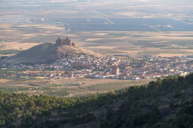La Calahorra Kalesi bir dağın tepesinde, bir kasaba var, ağaçlar var, güneş enerjisi santrali var.