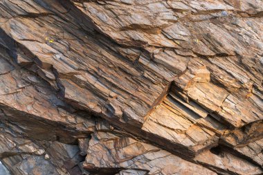 Kayaların düz olmayan yüzeyi, kaya gri ve kahverengidir.