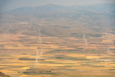 Güney İspanya 'da rüzgar tarlaları, ekinler ve dağlar var, dağlarda bir köy var.