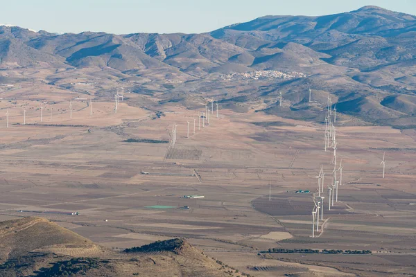 İspanya 'nın güneyinde rüzgar tarlası, ağaçlı dağlar, dağlarda bir kasaba var, gökyüzü açık.