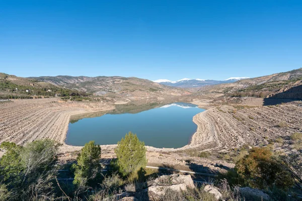 Güney İspanya 'da Beninar rezervuarı var, dağlar ve ağaçlar var, taşlar var ve gökyüzü açık.