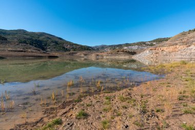 Güney İspanya 'da Beninar rezervuarı var, dağlar ve ağaçlar var, taşlar var ve gökyüzü açık.