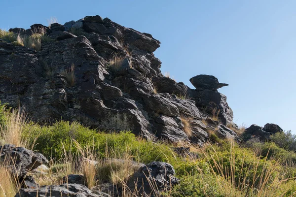 Sierra Nevada 'da kaya oluşumu, çalılar ve çimenler var, gökyüzü açık.