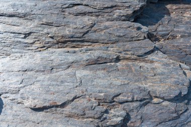 Kayaların düz olmayan yüzeyi, gri renkli kayanın yüzeyinde liken var.