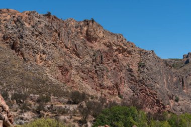 Güney İspanya 'da La Alpujarra' nın dağlık arazisi, ağaçlar ve çalılar var, gökyüzü açık.