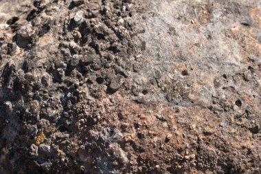 Kayaların düz olmayan yüzeyi, gri renkli kayanın yüzeyinde liken var.