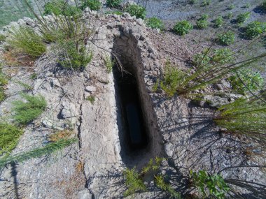 İspanya 'da bir su deposunun yanında eski bir kuyu var. Çimen ve taşlar.