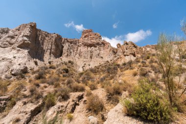 Güney İspanya 'da dağlık ve aşınmış bir arazi, bitki örtüsü var ve gökyüzü bulutlu.
