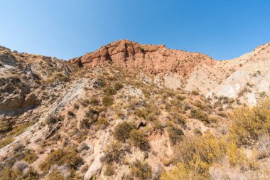 Güney İspanya 'da dağlık ve aşınmış bir arazi, bitki örtüsü var ve gökyüzü bulutlu.