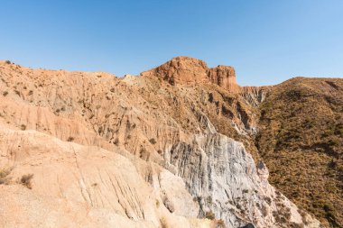 Güney İspanya 'da dağlık ve aşınmış bir arazi, bitki örtüsü var ve gökyüzü bulutlu.