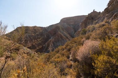 Güney İspanya 'da dağlık ve aşınmış bir arazi, bitki örtüsü var ve gökyüzü bulutlu.