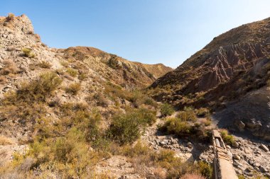 Güney İspanya 'da dağlık ve aşınmış bir arazi, bitki örtüsü var ve gökyüzü bulutlu.