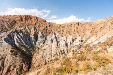 Güney İspanya 'da dağlık ve aşınmış bir arazi, bitki örtüsü var ve gökyüzü bulutlu.