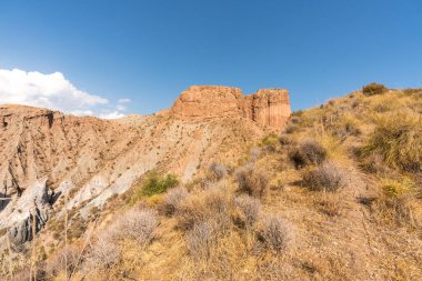 Güney İspanya 'da dağlık ve aşınmış bir arazi, bitki örtüsü var ve gökyüzü bulutlu.