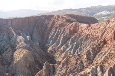 Güney İspanya 'da dağlık ve aşınmış bir arazi, bitki örtüsü var ve gökyüzü bulutlu.
