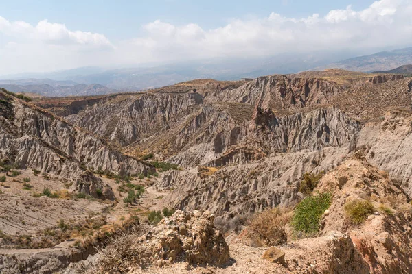 Güney İspanya 'da dağlık ve aşınmış bir arazi, bitki örtüsü var ve gökyüzü bulutlu.