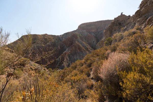 Güney İspanya 'da dağlık ve aşınmış bir arazi, bitki örtüsü var ve gökyüzü bulutlu.