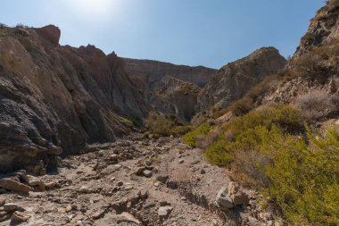 Güney İspanya 'da dağlık ve aşınmış bir arazi. Kuru bir vadi var, bitki örtüsü var ve gökyüzü açık.